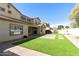 Large backyard with artificial turf, brick patio, and partial view of the home's exterior at 2428 E Iris Dr, Chandler, AZ 85286