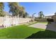 Expansive backyard featuring artificial grass, paved areas, and decorative white trellis at 2428 E Iris Dr, Chandler, AZ 85286