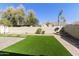 Wide backyard featuring artificial turf, paved areas, and mature trees at 2428 E Iris Dr, Chandler, AZ 85286