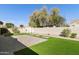 An expansive backyard featuring artificial turf, a paved patio, and decorative white trellis at 2428 E Iris Dr, Chandler, AZ 85286