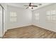 Bright bedroom with wood-look flooring, white walls, and white plantation shutters at 2428 E Iris Dr, Chandler, AZ 85286