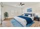 Staged primary bedroom features ceiling fan, shutters, wood-look laminate flooring and sliding glass door at 2428 E Iris Dr, Chandler, AZ 85286