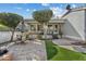 Picturesque backyard featuring a stone patio, synthetic grass, and a well-maintained lawn at 2626 E Valencia St, Gilbert, AZ 85296