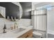 A stylish bathroom features a modern vanity with gold fixtures, a round mirror, and a shower-tub combination at 2626 E Valencia St, Gilbert, AZ 85296