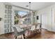 Dining area featuring a wooden table, modern chandelier, and a large window offering natural light at 2626 E Valencia St, Gilbert, AZ 85296