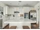 Open kitchen with white cabinetry, stainless steel appliances, subway tile backsplash, and center island with seating at 2626 E Valencia St, Gilbert, AZ 85296