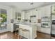 Sunlit white kitchen boasts stainless steel appliances, a subway tile backsplash, and island seating at 2626 E Valencia St, Gilbert, AZ 85296