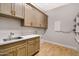 A laundry room with wood floors, cabinets and sink at 2775 S Baker Dr, Apache Junction, AZ 85119