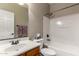 A clean bathroom features a shower-tub combo and a vanity with a white sink and wood cabinetry at 2798 W William Ln, San Tan Valley, AZ 85144