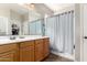 Bathroom featuring wood cabinets, a large mirror, and a shower with a curtain at 2798 W William Ln, San Tan Valley, AZ 85144