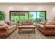 Comfortable lounge area with plush couches, a wooden coffee table, and a view of outdoor green space at 2798 W William Ln, San Tan Valley, AZ 85144