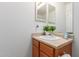 Bathroom with bright lighting, featuring a framed mirror above the sink and traditional cabinetry at 28549 N Dolomite Ln, San Tan Valley, AZ 85143