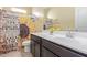 Well-lit bathroom featuring a sunflower shower curtain and a vanity with ample counter space at 3206 N 310Th Ln, Buckeye, AZ 85396