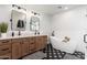 Modern bathroom with double vanity, soaking tub, and black and white patterned tile flooring at 345 W Wilshire Dr, Phoenix, AZ 85003