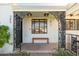 Inviting covered front porch with decorative metalwork, a wooden bench, and brick accents at 345 W Wilshire Dr, Phoenix, AZ 85003