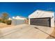 Attached garage with gray door, concrete driveway, and privacy wall offers convenient parking at 345 W Wilshire Dr, Phoenix, AZ 85003