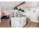 Open kitchen with white island, modern lighting, and stainless steel appliances, seamlessly connecting to the living room at 345 W Wilshire Dr, Phoenix, AZ 85003