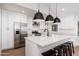 Bright open kitchen with modern white cabinets, stainless steel appliances, and large island with bar stools at 345 W Wilshire Dr, Phoenix, AZ 85003