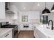 Well-lit kitchen with white cabinets, subway tile backsplash, stainless steel appliances, and wood-look floors at 345 W Wilshire Dr, Phoenix, AZ 85003