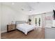 Bright primary bedroom featuring hardwood floors, a ceiling fan, and double doors to backyard at 345 W Wilshire Dr, Phoenix, AZ 85003