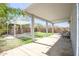 A view of backyard with a covered patio, sofa seating, stone oven, and well-manicured lawn at 35771 W Costa Blanca Dr, Maricopa, AZ 85138