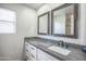 Bathroom featuring dual mirrors, modern fixtures, and a sleek gray countertop at 35771 W Costa Blanca Dr, Maricopa, AZ 85138