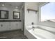 Elegant bathroom featuring a soaking tub, dual vanities, and wood-look flooring at 35771 W Costa Blanca Dr, Maricopa, AZ 85138