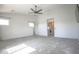 Spacious bedroom featuring neutral carpet, ceiling fan, and multiple windows at 35771 W Costa Blanca Dr, Maricopa, AZ 85138