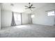 Large bedroom with neutral carpet, modern ceiling fan, and natural light at 35771 W Costa Blanca Dr, Maricopa, AZ 85138