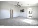 Large bedroom featuring neutral carpet, ceiling fan, and ensuite bathroom access at 35771 W Costa Blanca Dr, Maricopa, AZ 85138