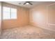 Cozy bedroom featuring neutral walls and carpet, a window, and a ceiling fan with light at 35771 W Costa Blanca Dr, Maricopa, AZ 85138