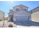 A front exterior view of a two story home with a two car garage and desert landscaping at 35771 W Costa Blanca Dr, Maricopa, AZ 85138