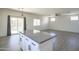 Kitchen island with gray countertops, opening to the spacious living area at 35771 W Costa Blanca Dr, Maricopa, AZ 85138