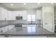 Close-up of the kitchen island with gray countertops and stainless steel appliances at 35771 W Costa Blanca Dr, Maricopa, AZ 85138