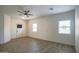 Bright and airy living area with a modern ceiling fan and durable wood-look floors at 35771 W Costa Blanca Dr, Maricopa, AZ 85138