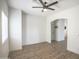 Bright living area with wood-look flooring, ceiling fan, and an arched doorway at 35771 W Costa Blanca Dr, Maricopa, AZ 85138