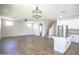 Spacious living room with wood floors, ceiling fan, and adjacent kitchen at 35771 W Costa Blanca Dr, Maricopa, AZ 85138