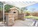 Close up view of a backyard stone oven under a pergola with stone countertop on each side at 35771 W Costa Blanca Dr, Maricopa, AZ 85138