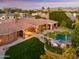 Stunning aerial view of the home's backyard featuring a pool, fire pit, lush greenery, and an outdoor living area at 3937 E Norcroft Cir, Mesa, AZ 85215