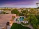 Captivating aerial view of the pool, outdoor living space, and landscaping with the city skyline in the background at 3937 E Norcroft Cir, Mesa, AZ 85215