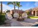 Comfortable hanging chairs surround a stone fire pit, creating an inviting outdoor lounge area for relaxation and socializing at 3937 E Norcroft Cir, Mesa, AZ 85215