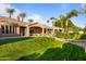 Expansive backyard with lush green lawn, palm trees, and a covered patio, perfect for outdoor entertaining and relaxation at 3937 E Norcroft Cir, Mesa, AZ 85215