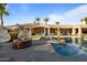 Outdoor living space with a fire pit, cozy hanging chairs, and a sparkling pool, perfect for entertaining and relaxation at 3937 E Norcroft Cir, Mesa, AZ 85215