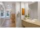 Well-lit bathroom with a granite countertop, wood vanity, and adjacent shower at 3937 E Norcroft Cir, Mesa, AZ 85215