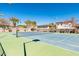 Well-maintained community tennis court featuring pristine surface and net, surrounded by lush green grass at 3937 E Norcroft Cir, Mesa, AZ 85215