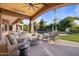 Inviting covered patio with a fire pit, comfy seating, and views of the lush backyard and pool at 3937 E Norcroft Cir, Mesa, AZ 85215