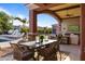 Covered patio with an outdoor dining area, lounge chairs, and a beautiful view of the pool and gardens at 3937 E Norcroft Cir, Mesa, AZ 85215