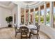 Elegant dining area with a chandelier, marble table, and large windows overlooking the pool at 3937 E Norcroft Cir, Mesa, AZ 85215