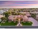 Striking front exterior showcasing manicured landscaping, mature palm trees, grand entryway, and circular driveway at 3937 E Norcroft Cir, Mesa, AZ 85215