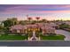 A picturesque single-story house with a tile roof, a water feature, and lush landscaping viewed at twilight at 3937 E Norcroft Cir, Mesa, AZ 85215